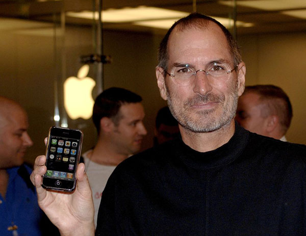 Steve Jobs holds up the first iPhone at a launch event in September 2007.